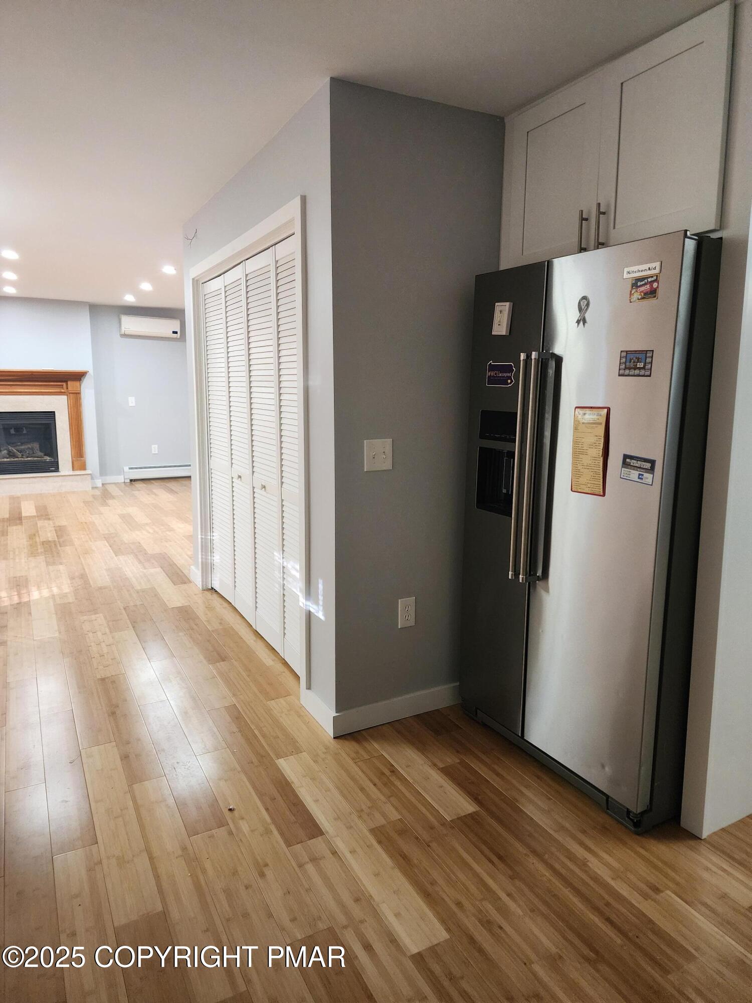 283 Pocono Boulevard Bushkill, PA 18324 - Photo 22 of 44 a view of a refrigerator in kitchen and an empty room with wooden floor windows