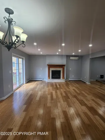 an empty room with wooden floor and fan
