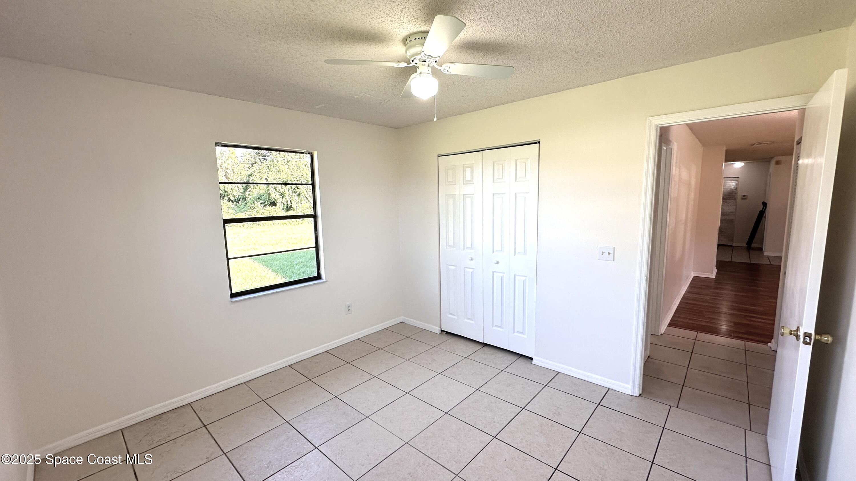 3807 Jupiter Boulevard Southeast Palm Bay, FL 32909 - Photo 14 of 34 wooden floor in an empty room with a window