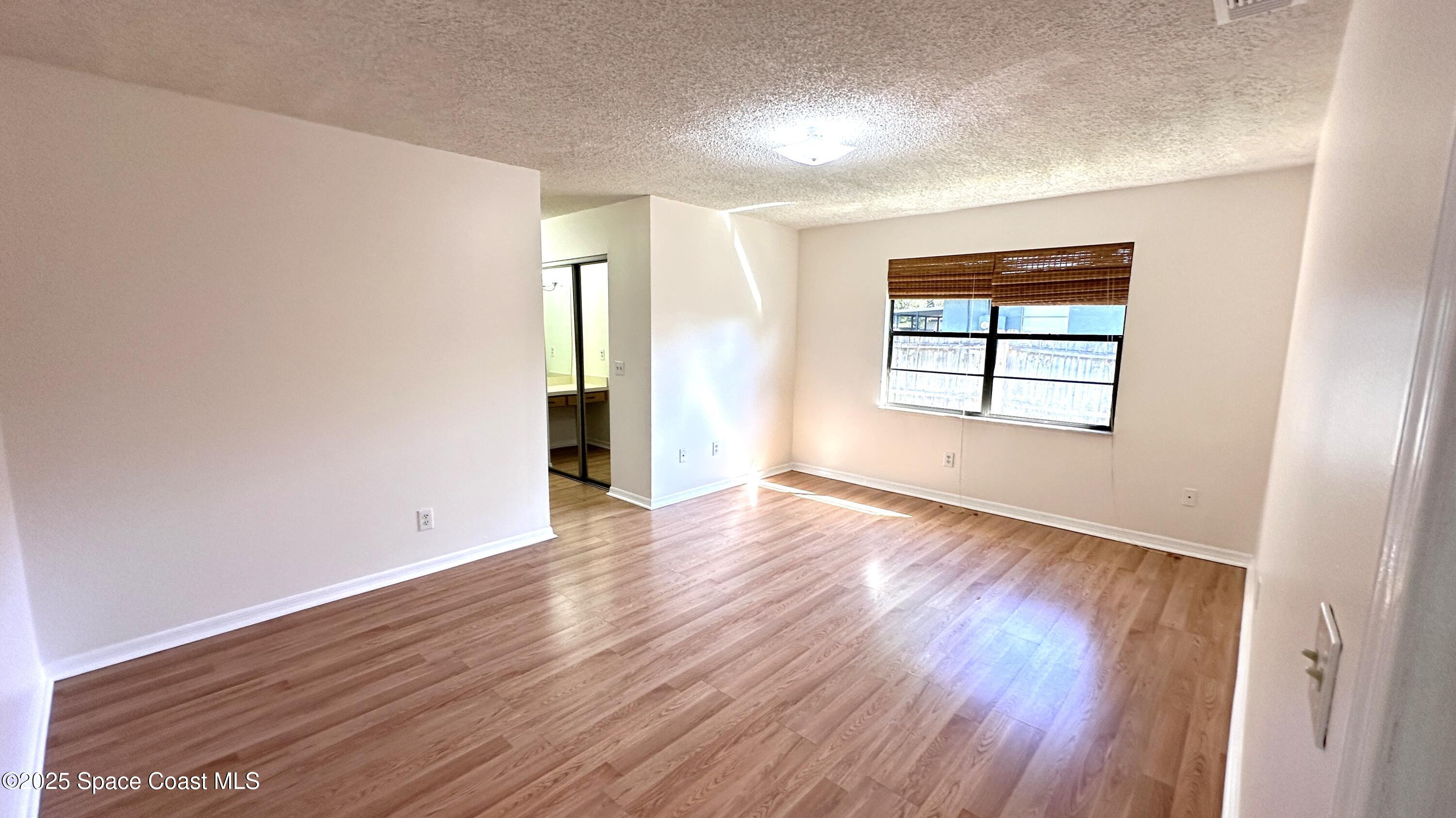 3807 Jupiter Boulevard Southeast Palm Bay, FL 32909 - Photo 22 of 34 an empty room with wooden floor and windows