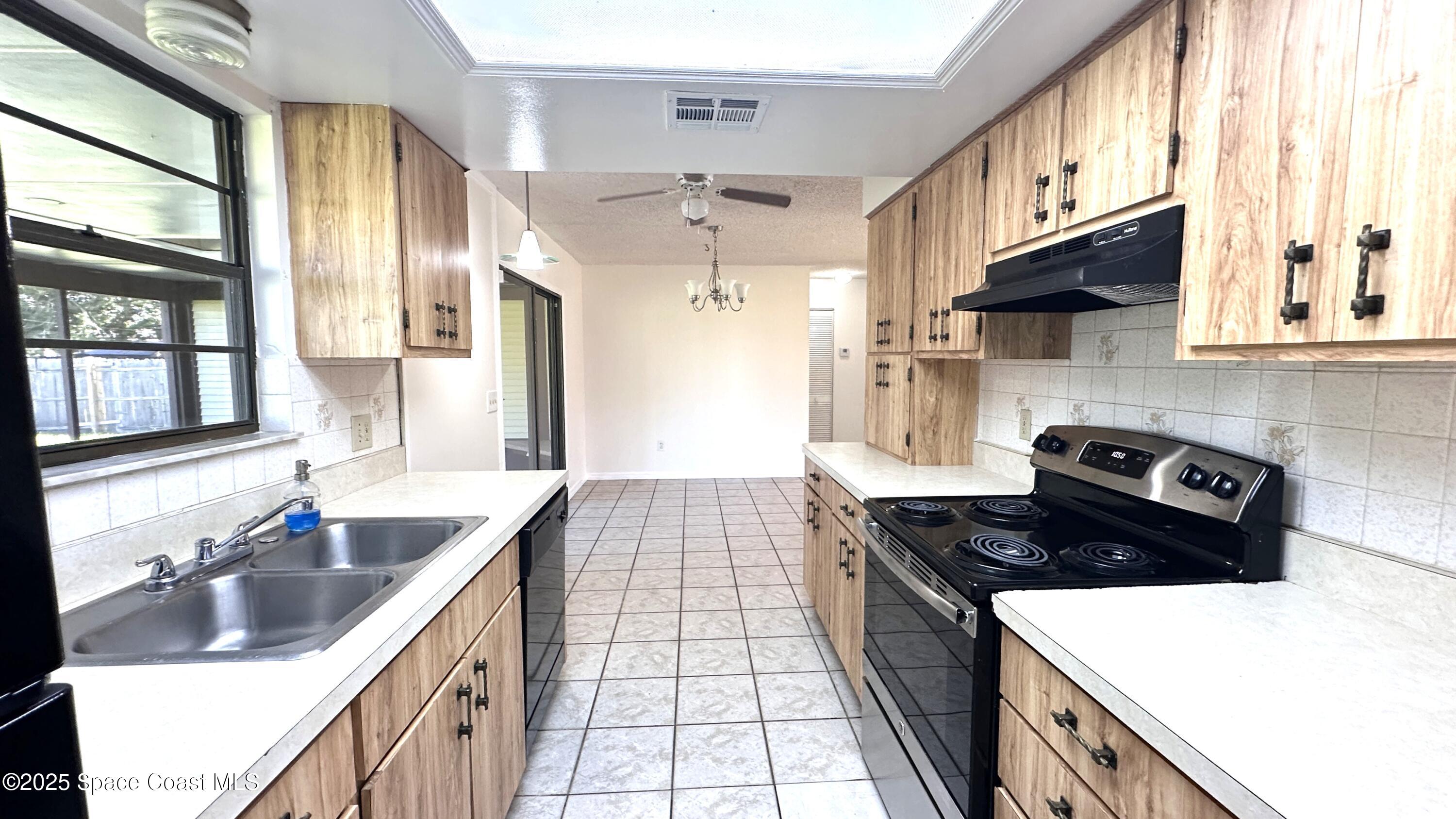 3807 Jupiter Boulevard Southeast Palm Bay, FL 32909 - Photo 31 of 34 a kitchen with a sink stove top oven and cabinets