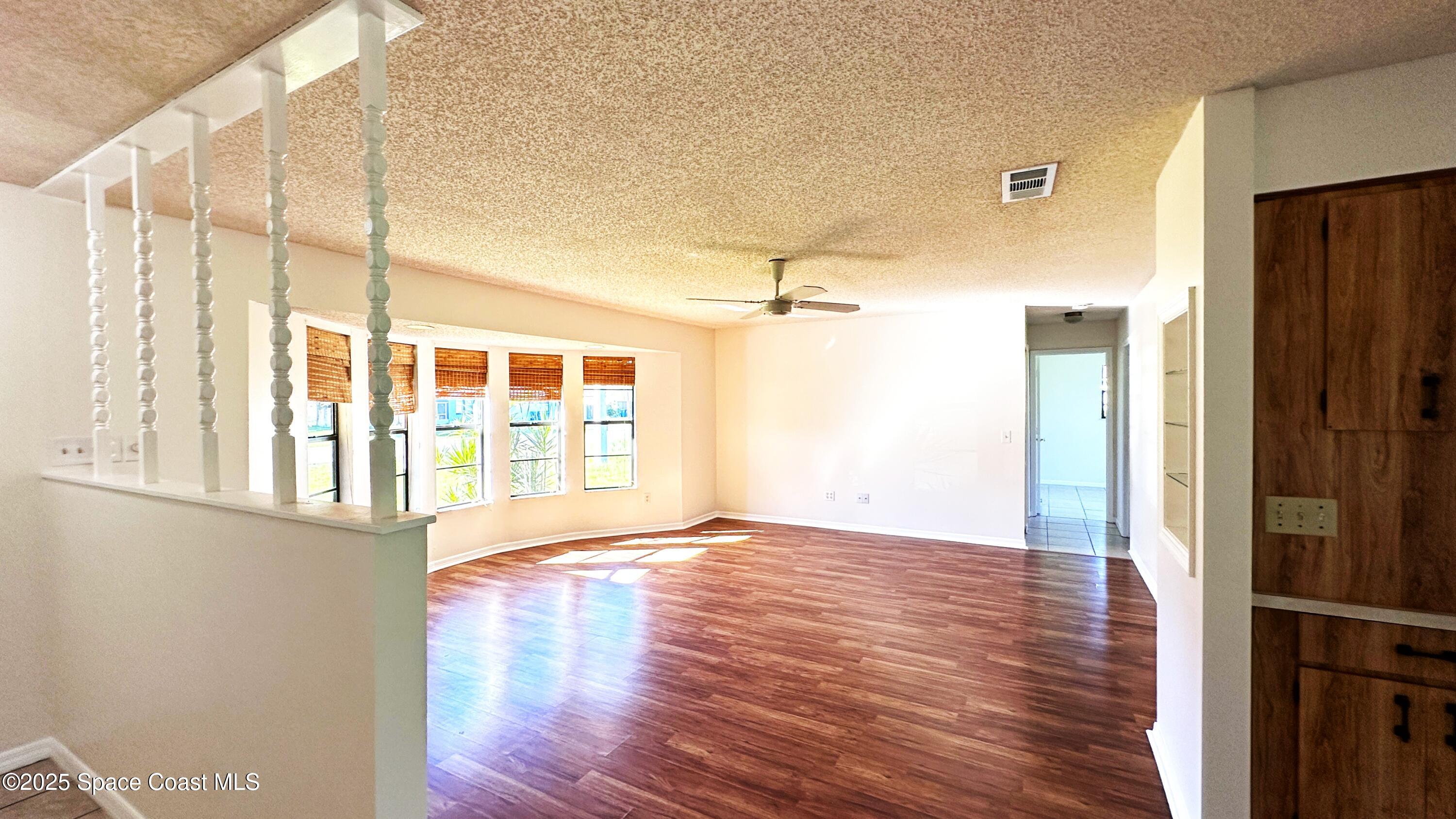3807 Jupiter Boulevard Southeast Palm Bay, FL 32909 - Photo 5 of 34 a view of an empty room with wooden floor and a window