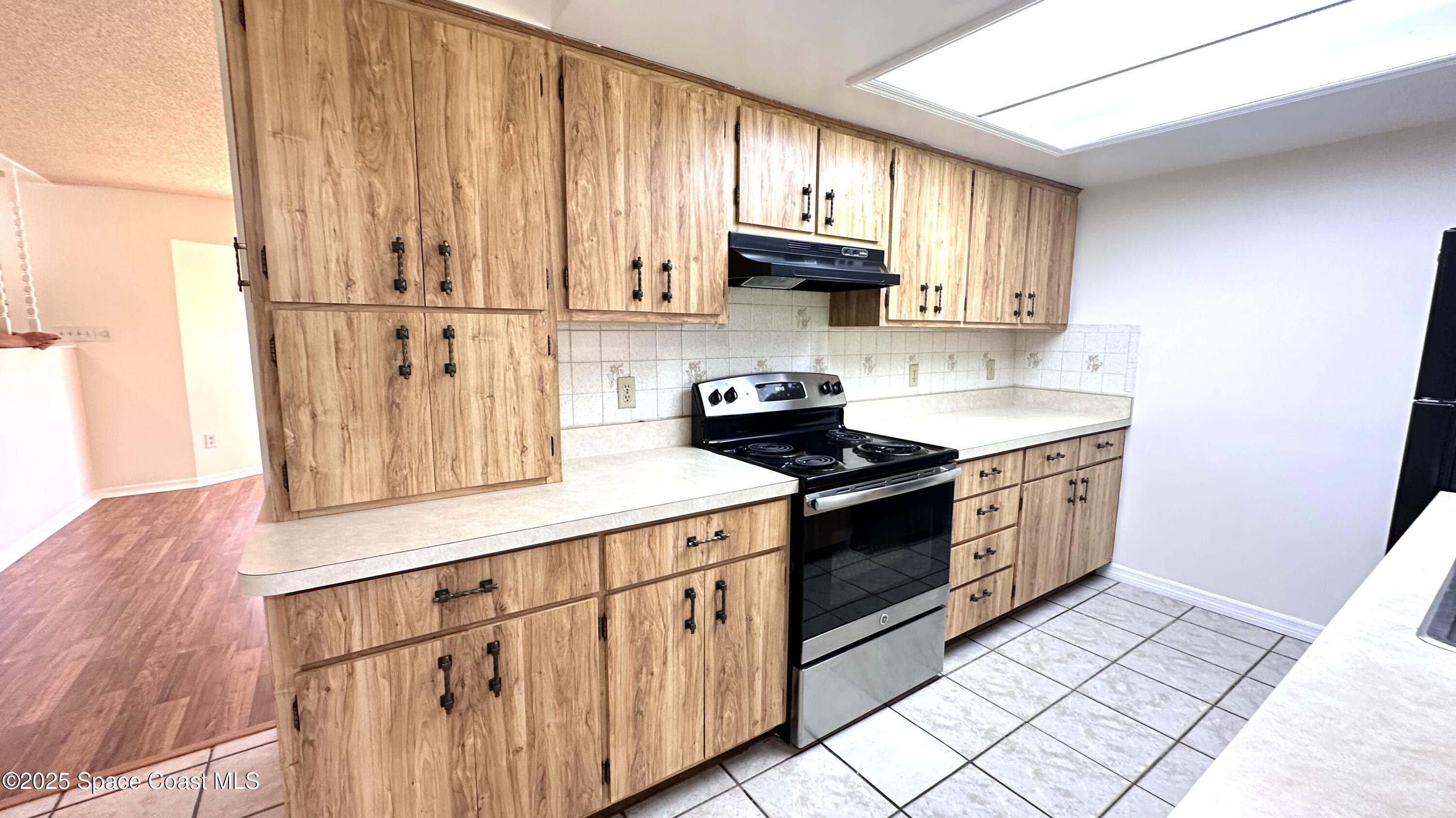 3807 Jupiter Boulevard Southeast Palm Bay, FL 32909 - Photo 7 of 34 a kitchen with stainless steel appliances granite countertop a sink a stove a refrigerator and cabinets