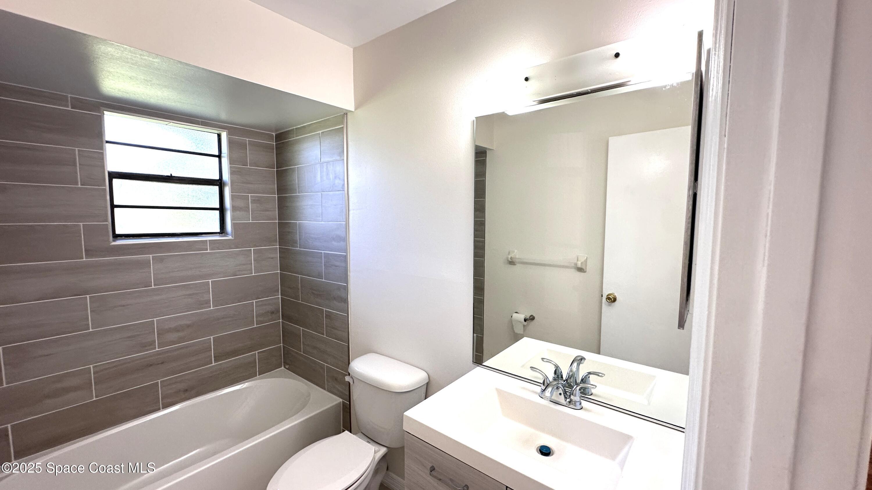 3807 Jupiter Boulevard Southeast Palm Bay, FL 32909 - Photo 10 of 34 a bathroom with a sink a toilet and shower