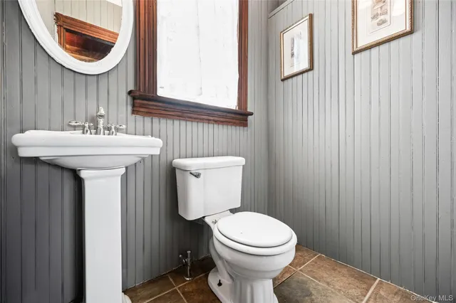 a bathroom with a toilet a sink and a mirror
