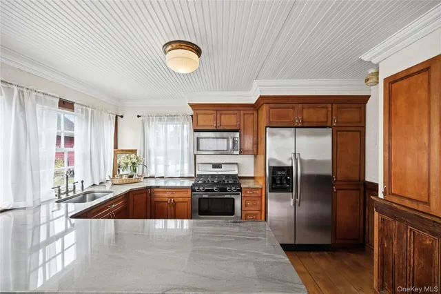 a kitchen with granite countertop a refrigerator and a sink