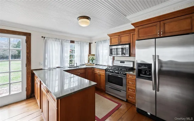 a kitchen with stainless steel appliances granite countertop a sink a stove and a refrigerator