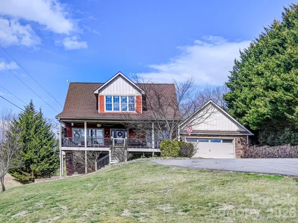 a view of a house with a big yard and large trees