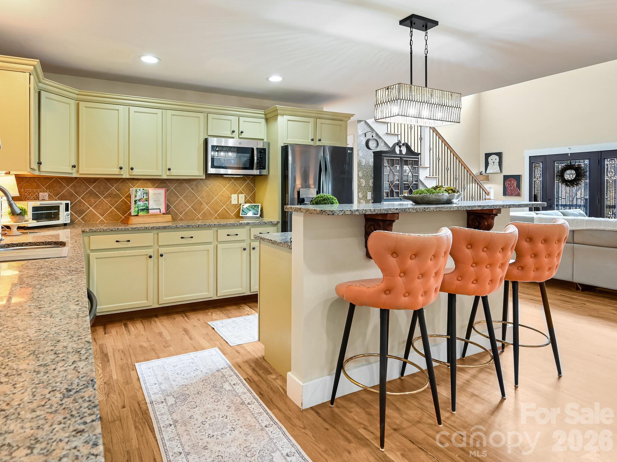1645 Ivy Hill Road Marshall, NC 28753 - Photo 11 of 36 a large kitchen with stainless steel appliances kitchen island granite countertop a table chairs in it and a wooden floors