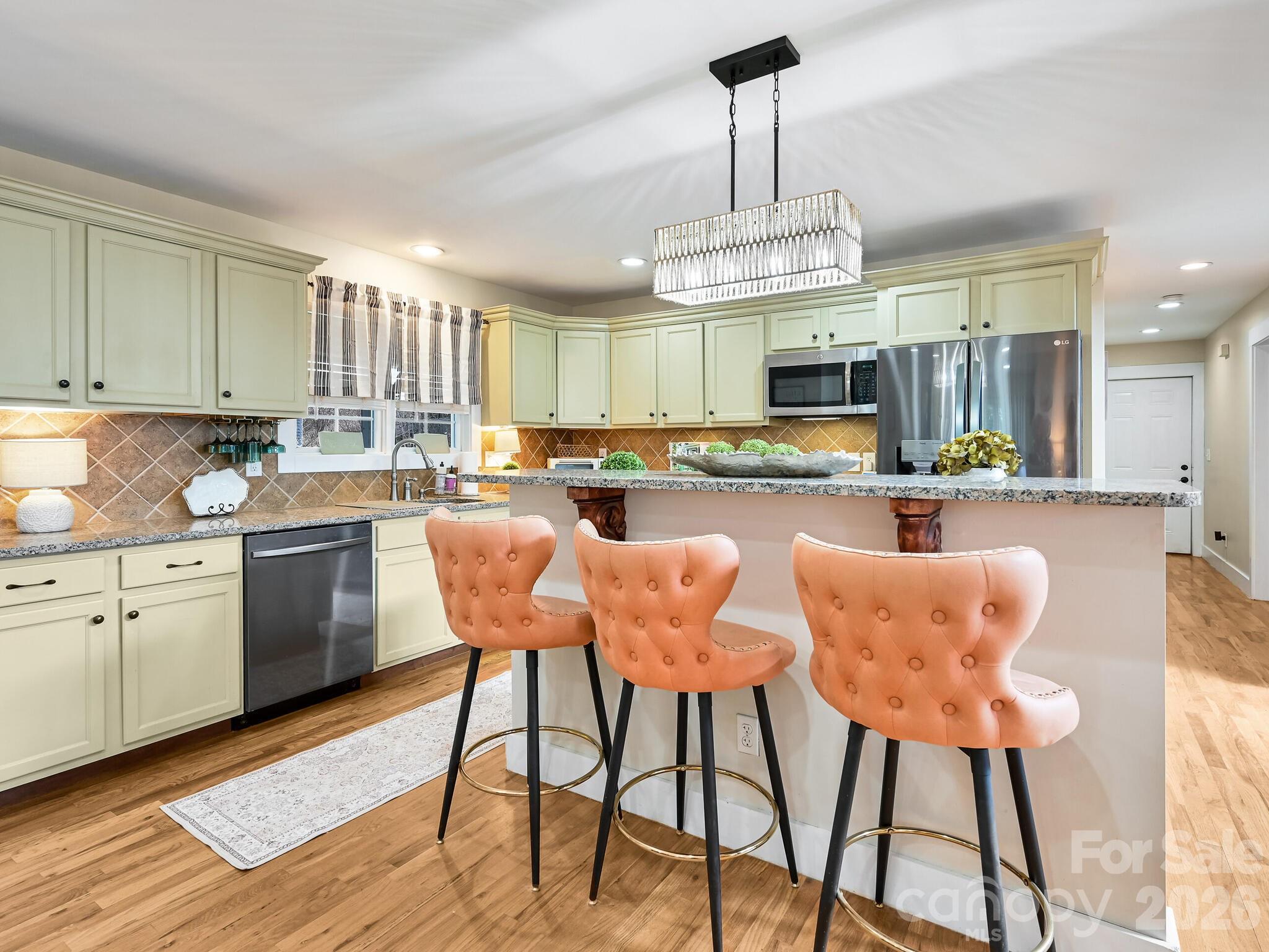1645 Ivy Hill Road Marshall, NC 28753 - Photo 14 of 36 a kitchen with stainless steel appliances granite countertop a stove top oven a refrigerator and chairs