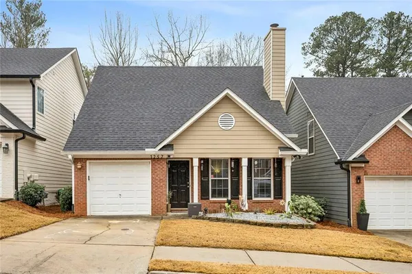 a front view of a house with a garden and yard