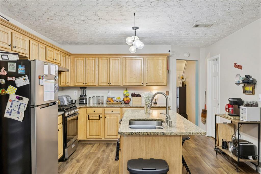 1257 Gates Circle Southeast Atlanta, GA 30316 - Photo 11 of 26 a kitchen with stainless steel appliances granite countertop a stove top oven a refrigerator a sink and dishwasher with white cabinets