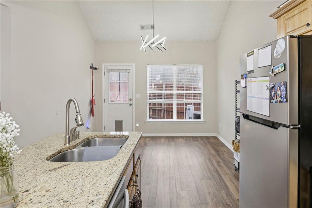 1257 Gates Circle Southeast Atlanta, GA 30316 - Photo 8 of 26 a kitchen with a refrigerator a sink and dishwasher with wooden floor
