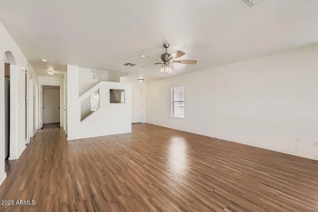 a view of a livingroom with wooden floor and a ceiling fan