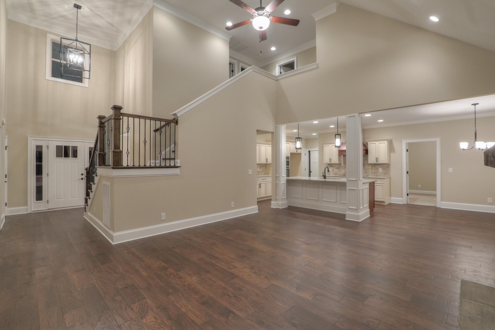 2219 Cairo Bend Road Lebanon, TN 37087 - Photo 8 of 30 an empty room with wooden floor and a kitchen