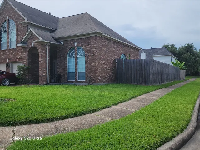 a view of a house with a small yard and wooden fence