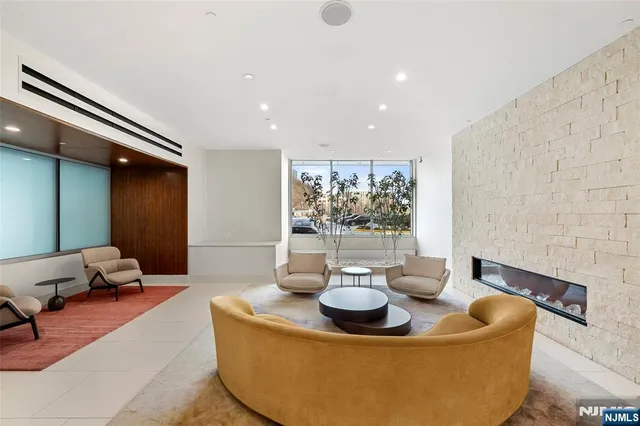 a living room with couches and a dining table with garden view