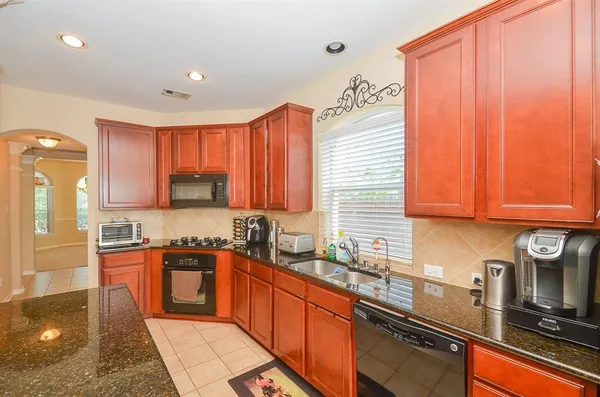 a kitchen with stainless steel appliances granite countertop a sink stove and cabinets