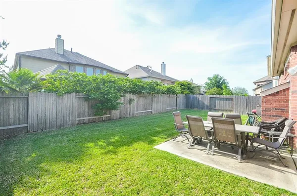 a view of backyard with a table and chairs in patio