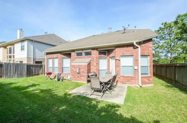 a patio with table and chairs and potted plants