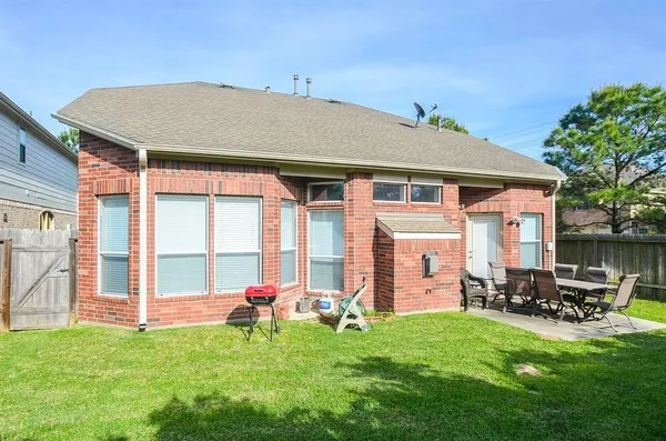 a backyard of a house with table and chairs