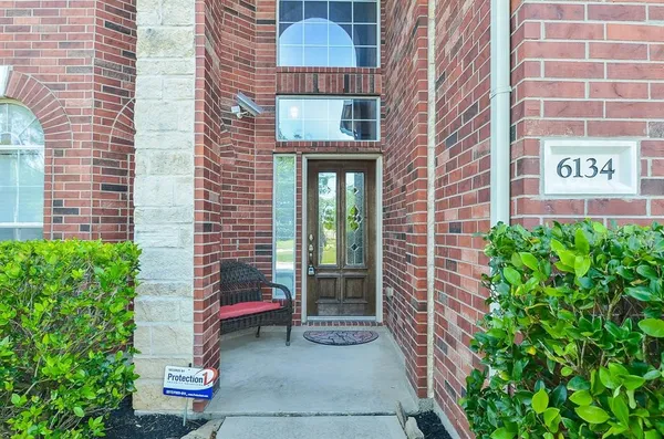 a view of a brick house with a yard and potted plants