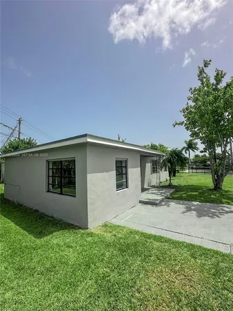 a backyard of a house with table and chairs