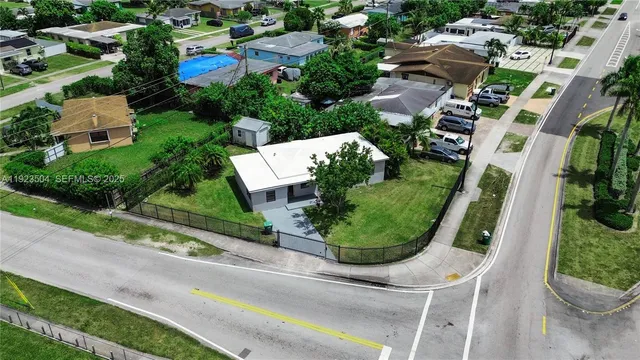 an aerial view of residential house with outdoor space and trees all around