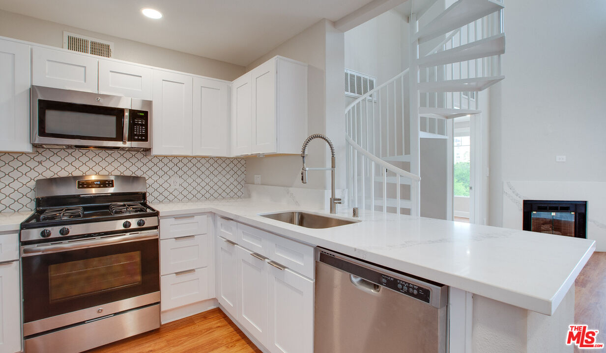 a kitchen with stainless steel appliances a sink stove and microwave