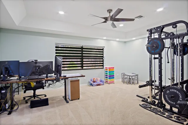 a room with gym equipment and view of kitchen