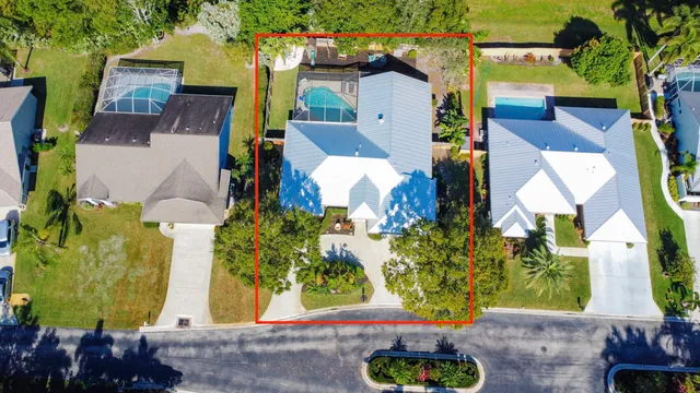 an aerial view of a residential houses with yard