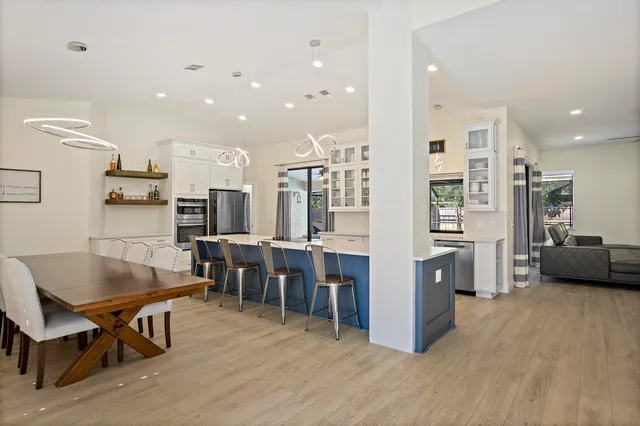 a living room with stainless steel appliances kitchen island granite countertop furniture wooden floor and a kitchen view