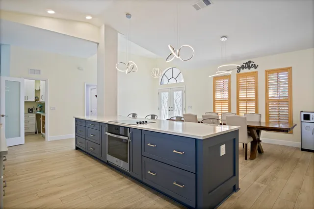 a spacious bathroom with a granite countertop double vanity sink a large mirror and a bathtub