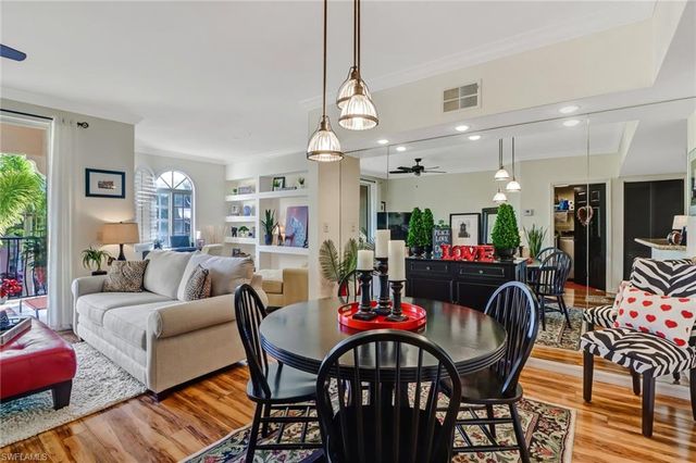 a living room with furniture a dining table and a chandelier