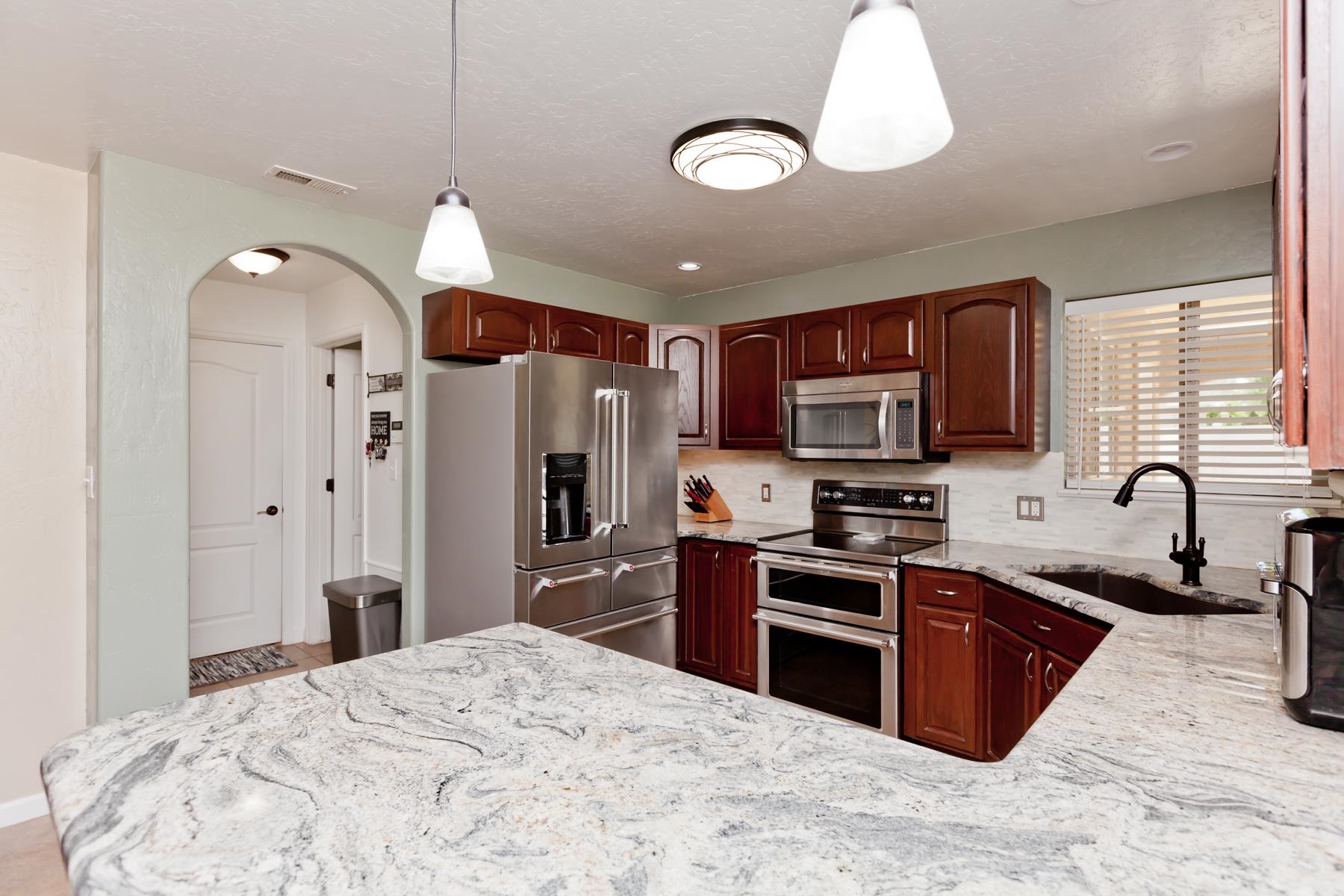 718 Sabil Drive Fruita, CO 81521 - Photo 2 of 35 a kitchen with stainless steel appliances granite countertop a stove refrigerator sink and microwave