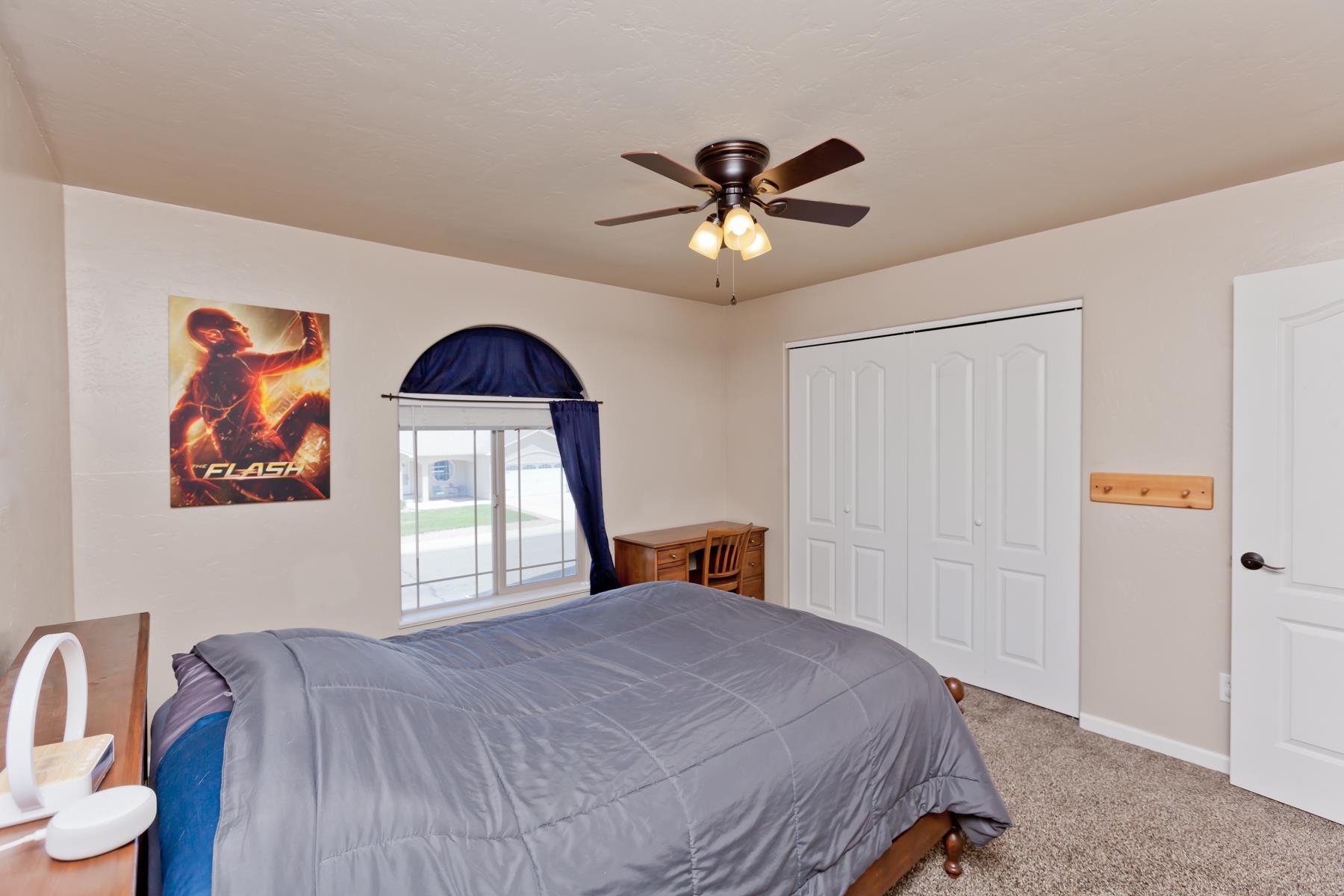 718 Sabil Drive Fruita, CO 81521 - Photo 21 of 35 a bedroom with a bed and a chandelier