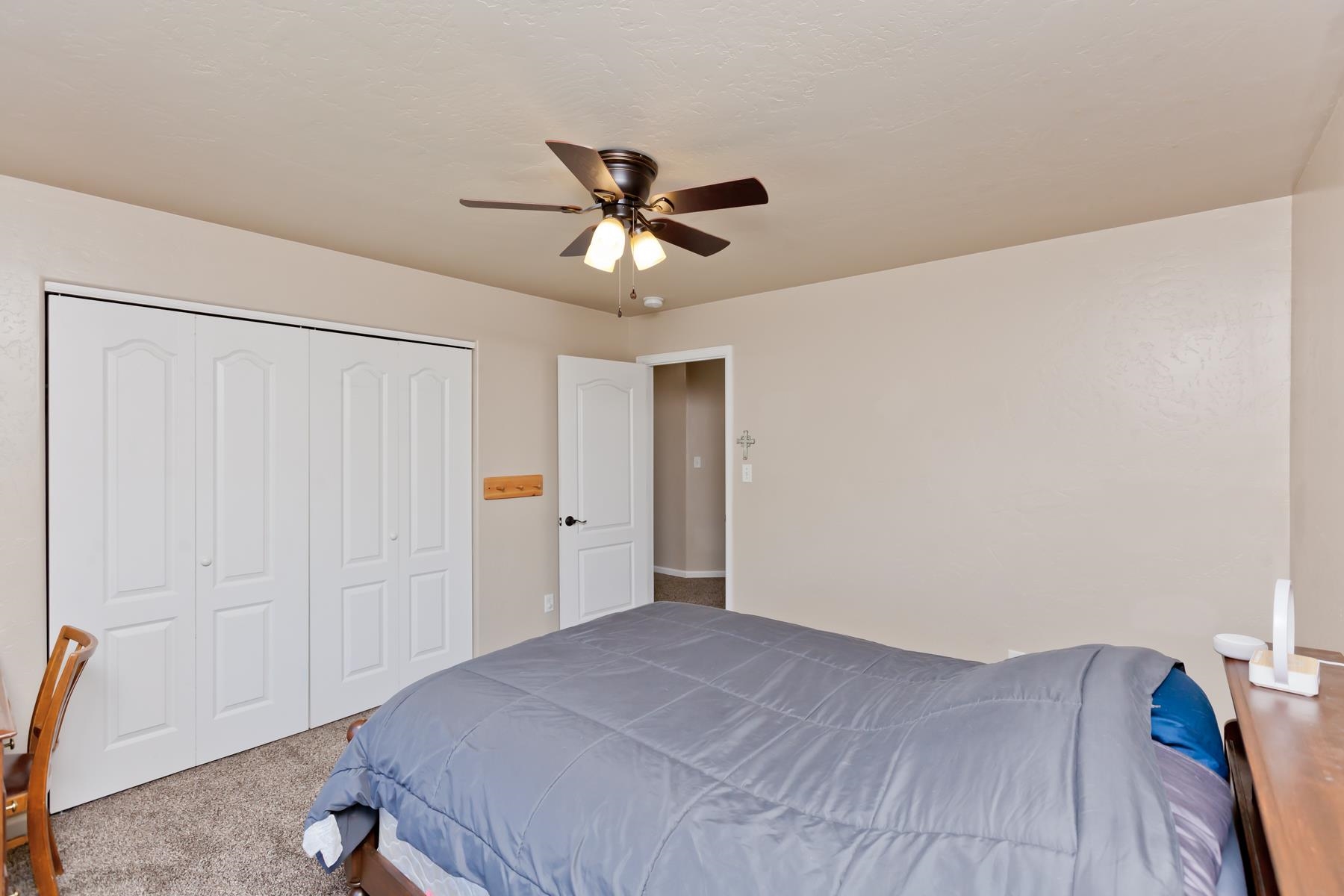 718 Sabil Drive Fruita, CO 81521 - Photo 22 of 35 a bedroom with a bed and a chandelier