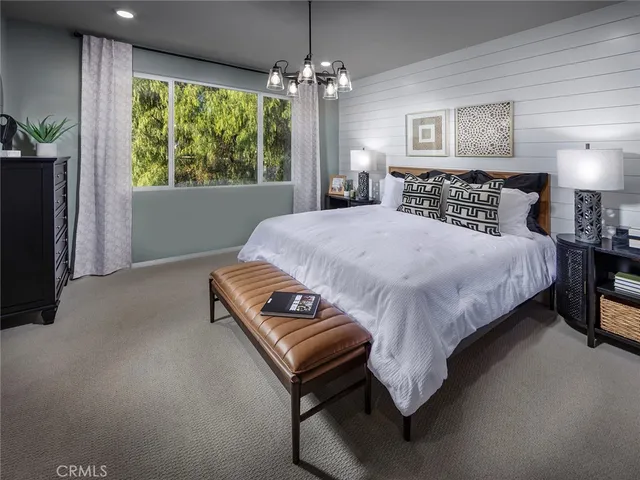 a bed sitting in a spacious bedroom next to a window