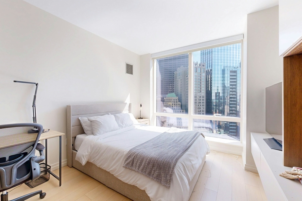 1 Franklin Street, Unit 2308 Boston, MA 02110 - Photo 21 of 41 a bedroom with a bed and a flat tv screen next to a window