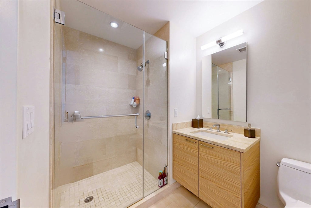 1 Franklin Street, Unit 2308 Boston, MA 02110 - Photo 25 of 41 a bathroom with a sink a toilet a mirror and shower