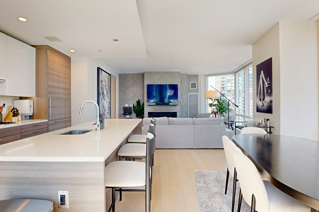 1 Franklin Street, Unit 2308 Boston, MA 02110 - Photo 10 of 41 a large living room with stainless steel appliances kitchen island granite countertop furniture and a large window