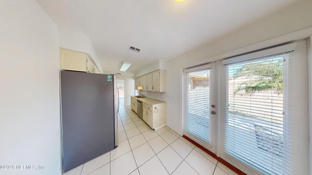 a kitchen with a refrigerator and white cabinets