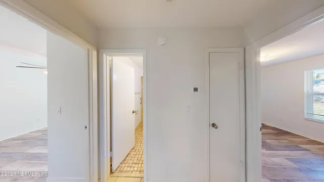 a view of bathroom with a sink mirror and window