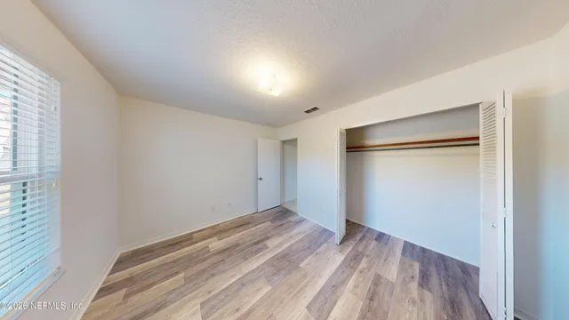 a view of empty room with wooden floor