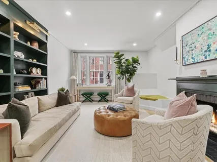 a living room with furniture and a painting on the wall
