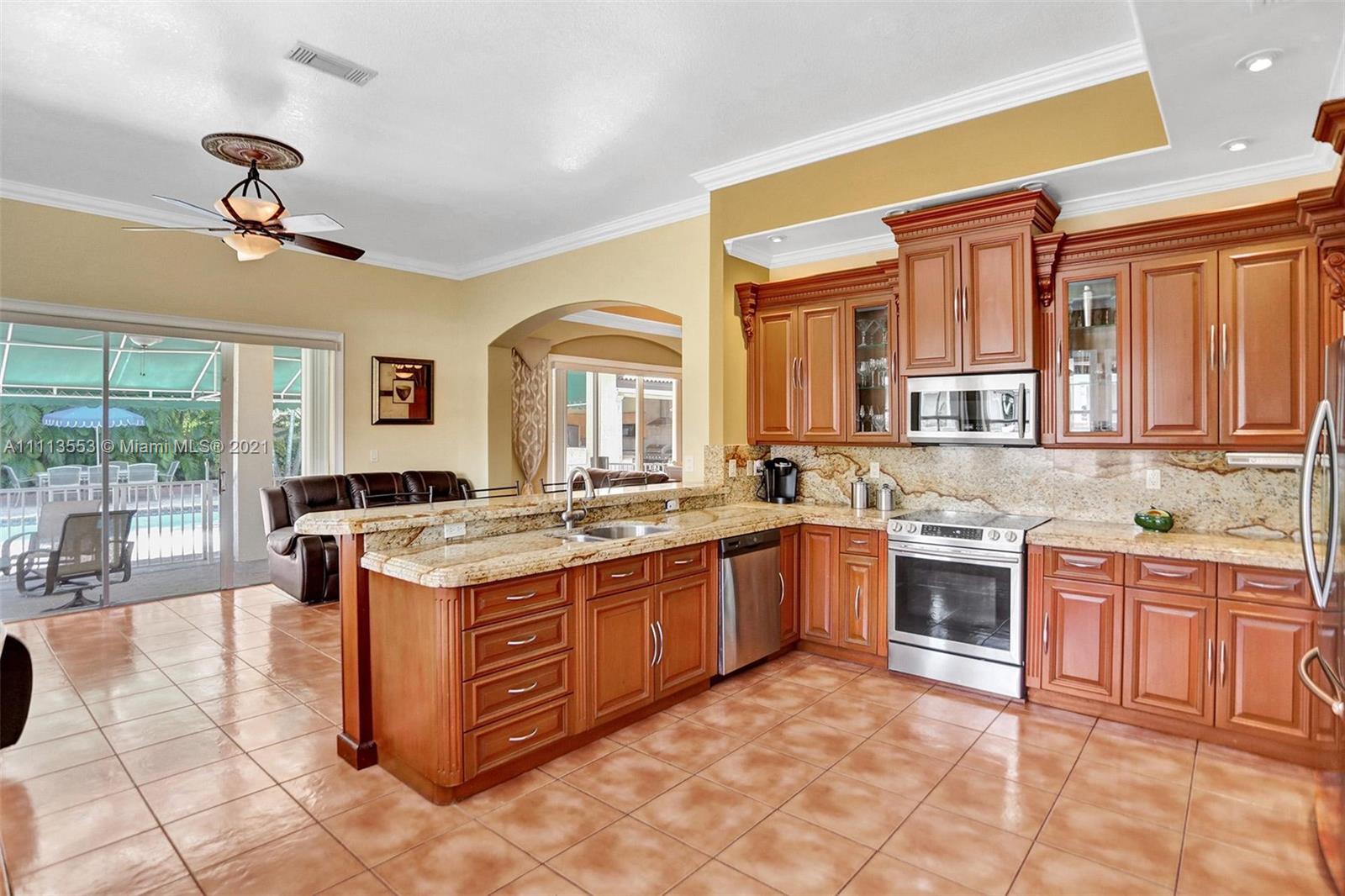 15816 Southwest 103rd Lane Miami, FL 33196 - Photo 11 of 49 a large kitchen with stainless steel appliances granite countertop a stove and large cabinets