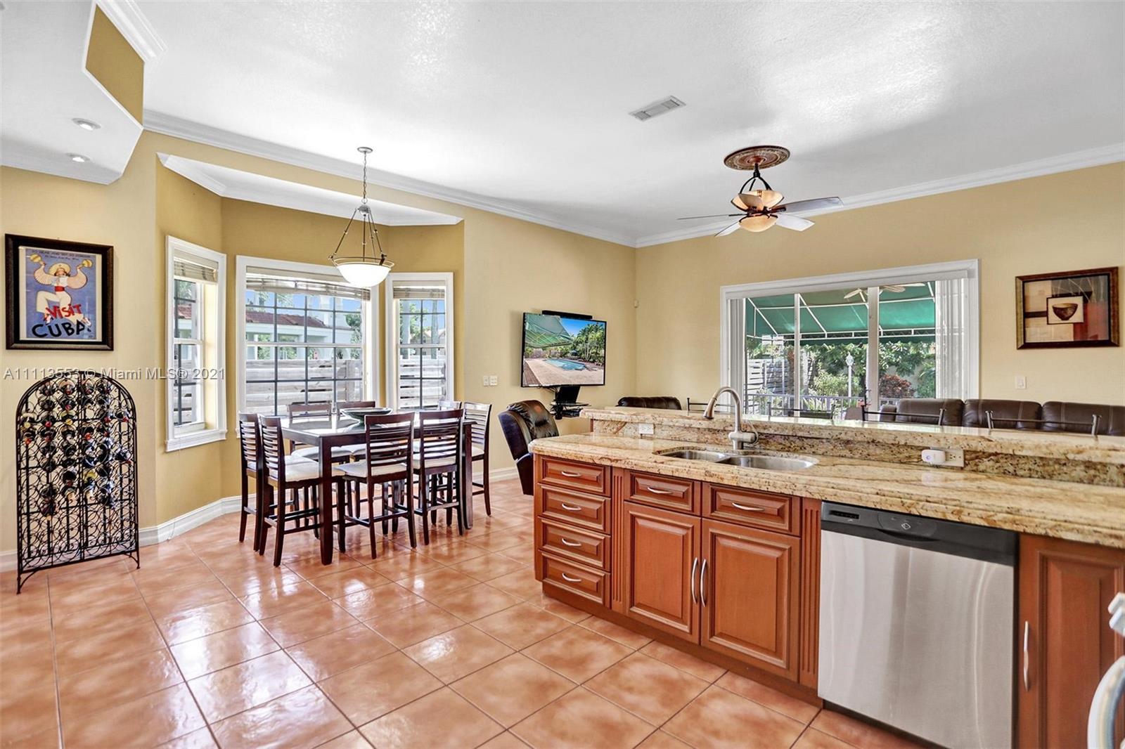 15816 Southwest 103rd Lane Miami, FL 33196 - Photo 12 of 49 a kitchen with a table chairs and wooden cabinets