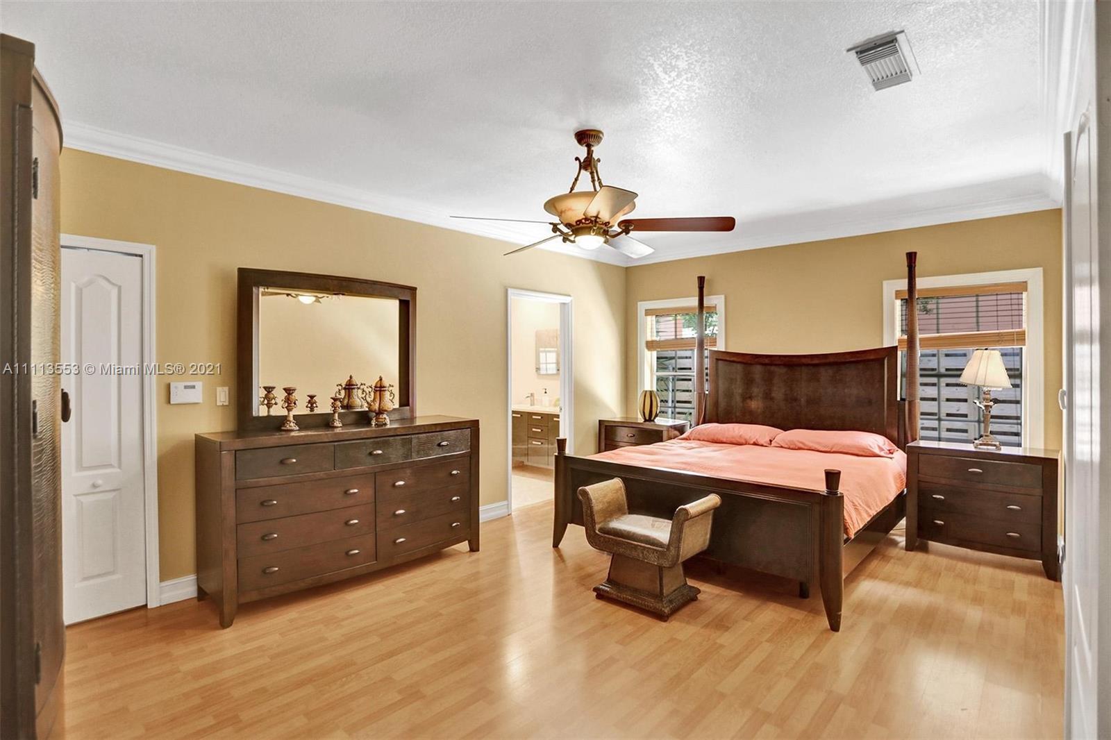 15816 Southwest 103rd Lane Miami, FL 33196 - Photo 16 of 49 a spacious bedroom with a bed and wooden floor