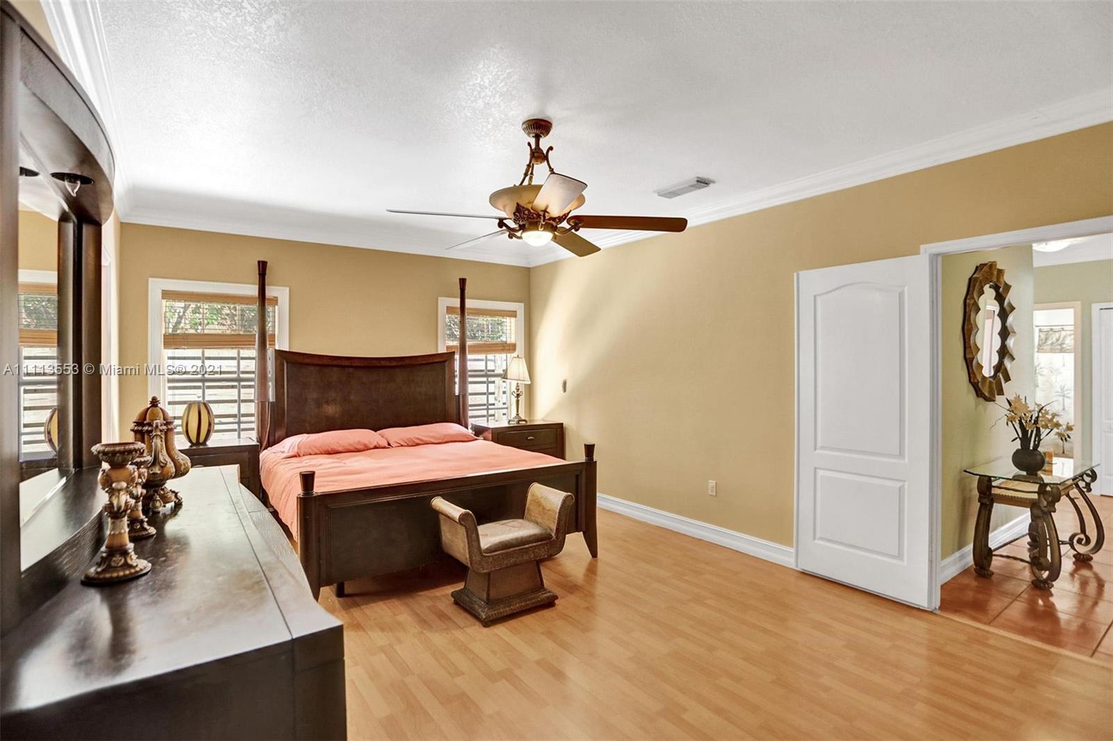 15816 Southwest 103rd Lane Miami, FL 33196 - Photo 17 of 49 a bedroom with a bed and a chandelier