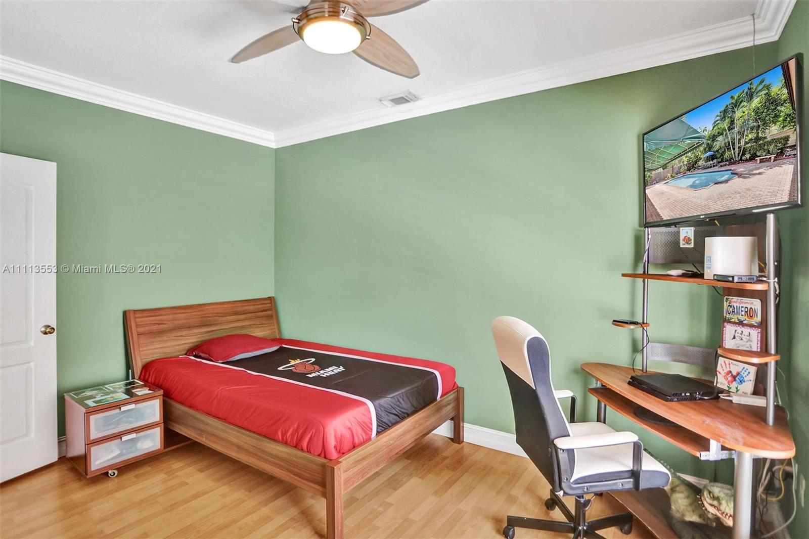 15816 Southwest 103rd Lane Miami, FL 33196 - Photo 24 of 49 a bedroom with a bed and a chandelier